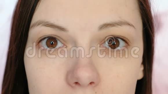 年轻的黑发女人看着相机眼睛和鼻子特写视频的预览图