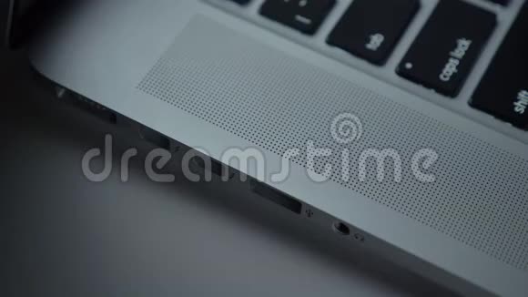 特写镜头的手快速插入USB电缆到笔记本电脑的黑桌背景视频的预览图