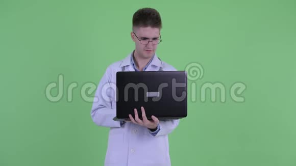 快乐的年轻医生一边用笔记本电脑一边思考视频的预览图