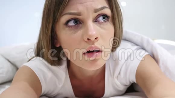 年轻女子感到害怕和困惑躺在床上视频的预览图
