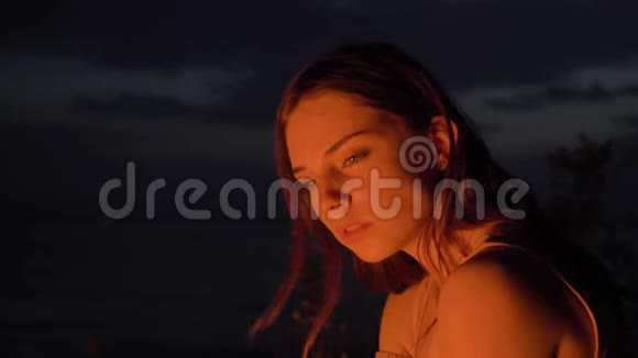 年轻的白种人姜黄色温柔的女孩坐在大自然的炉火旁看着镜头肖像视频的预览图