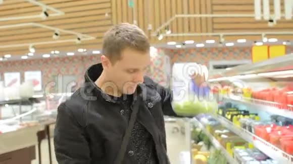 年轻有魅力的人在超市里选择绿色葡萄购买有机食品视频的预览图