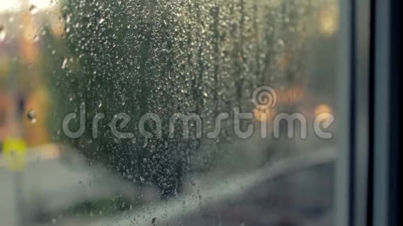 夜城的灯火扭曲的玻璃窗户上的液体雨滴日落时分的汽车交通信号灯悲伤视频的预览图