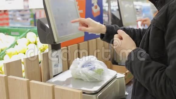 超市自助服务使用体重秤购买新鲜水果的人视频的预览图