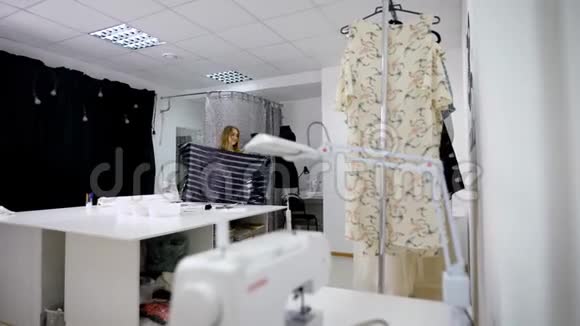休闲服装的时装设计师正在服装制作车间使用人体模型对服装进行测量图像视频的预览图