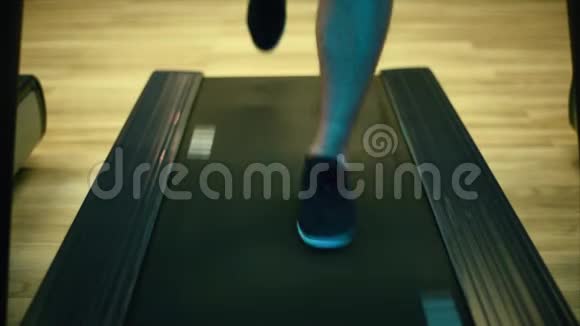 穿着运动鞋的男腿在轨道模拟器上奔跑关门视频的预览图