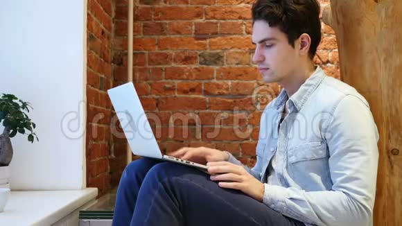 穿着笔记本电脑坐在楼梯上的进攻性思考者视频的预览图