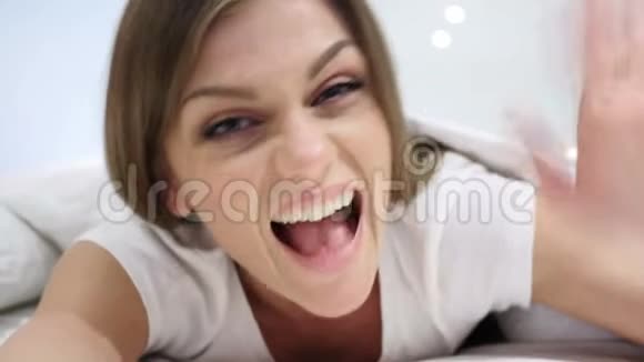 你好欢迎在床上挥手的快乐女人视频的预览图