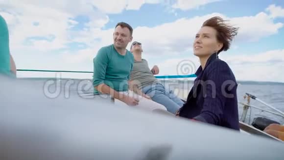 四个老朋友只是随意地坐在游艇上在海上航行啜饮香槟聊天视频的预览图