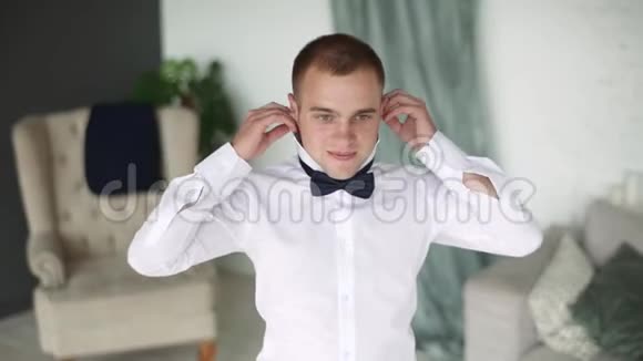 一个穿白色衬衫的人脱下蝴蝶结商人解开了领带上的扣视频的预览图