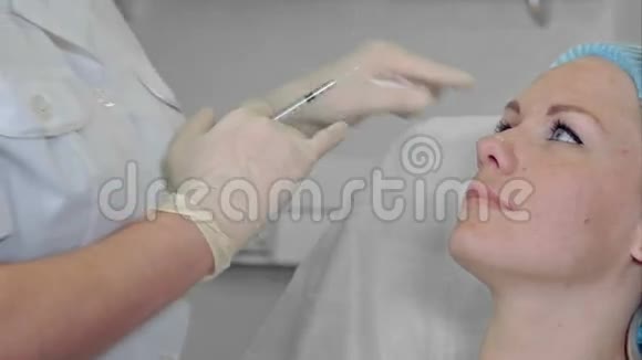 专业美容师为她的女性客户做美容注射振兴女性客户抗衰老肉毒素美容填充物视频的预览图