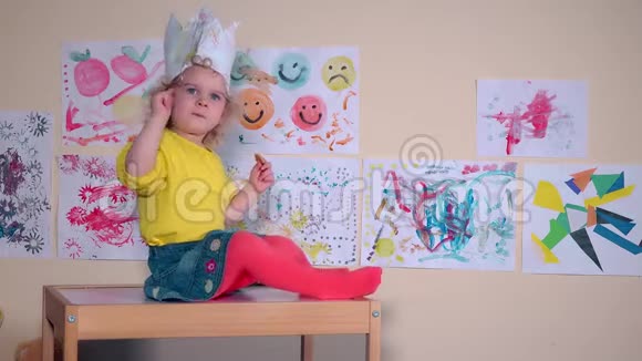 愤怒的漂亮孩子坐在桌子上吃饼干墙上的画视频的预览图