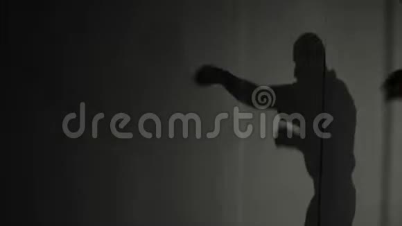 男性拳击手训练的影子练习拳打脚踢在战斗之前一个移动的影子视频的预览图