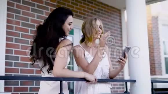 女朋友看着节日期间在智能手机上拍摄的照片女士们站在外面温暖的地方视频的预览图