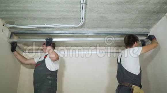 男建筑工人在室内建筑工地组装金属干墙型材视频的预览图