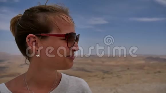 从悬崖边欣赏沙漠风景快乐女旅行者视频的预览图