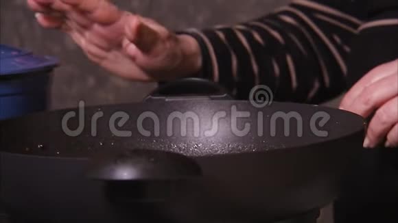 双手指着紧闭的锅然后伸手去拿视频的预览图