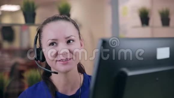 古怪的女人在一间干净明亮的办公室里用耳机说话呼叫中心视频的预览图