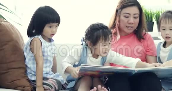 一位白种人的母亲和她的孩子们在卡通书上看滑稽的卡通片视频的预览图