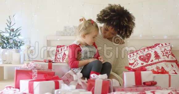 带着圣诞礼物躺在床上的女儿和母亲视频的预览图