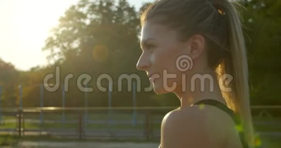 阳光明媚的一天女人在体育场奔跑的肖像视频的预览图