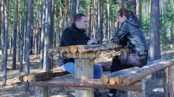 在美丽的秋天森林里一对年轻的夫妇在微笑着聊天视频的预览图