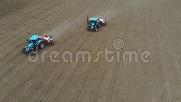 空中勘测俯视图春天有两台拖拉机在田间用专用的精密播种机种植玉米视频的预览图