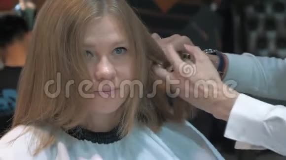 理发师的特写剪女青年的头发视频的预览图
