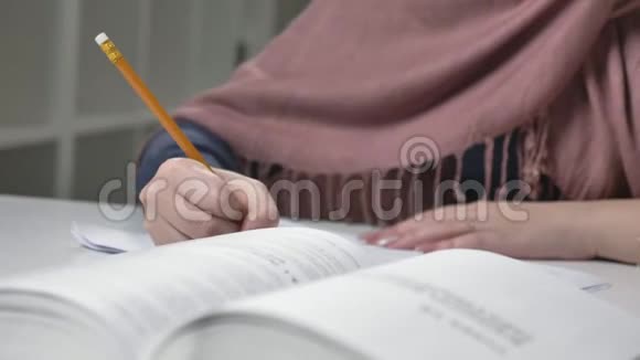 漂亮的女人的手写在笔记本上铅笔修指甲特写办公室里的阿拉伯妇女每秒60帧视频的预览图