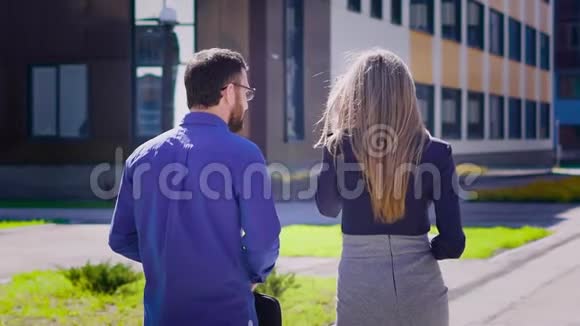 商人和女商人走在一起的后景穿着衬衫的帅哥在大楼里散步视频的预览图