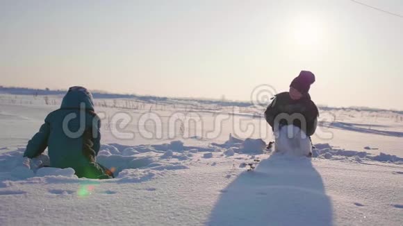 孩子们在冬天的新鲜空气中玩耍扔雪球户外运动视频的预览图