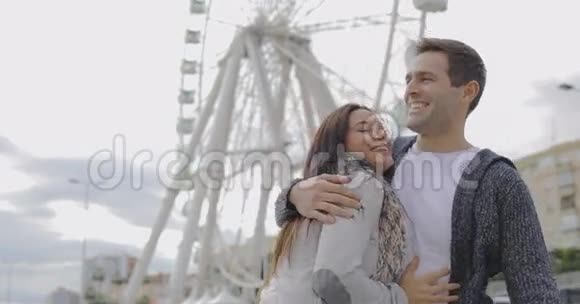 年轻夫妇站在摩天轮前视频的预览图