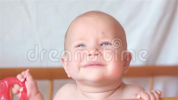 婴儿站在床上哭着手里拿着一个玩具视频的预览图