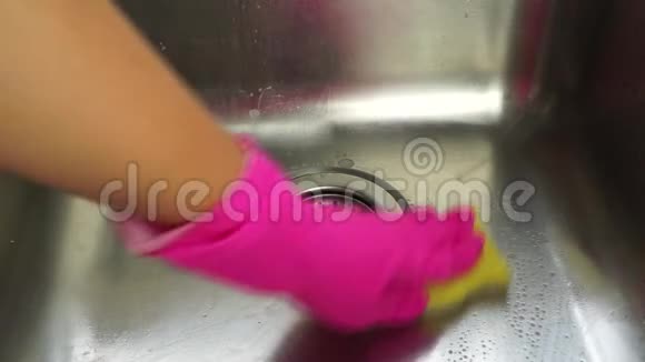 女性手戴粉色橡胶手套清洗金属水槽视频的预览图