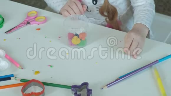 一个快乐的小女孩从一个容器里拿出五颜六色的塑料桌面上摆着数字和彩色铅笔视频的预览图