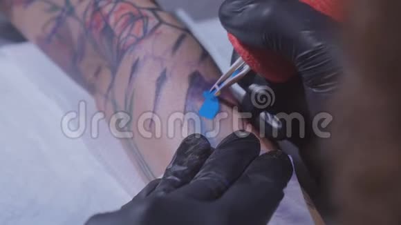 专业纹身师在一个年轻女孩的手上做纹身纹身师在工作室做纹身特写视频的预览图