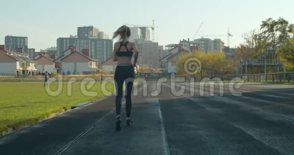 阳光明媚的一天女人在体育场跑步视频的预览图