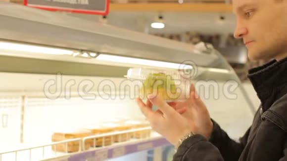 年轻人在超市冰箱货架上挑选蛋糕视频的预览图