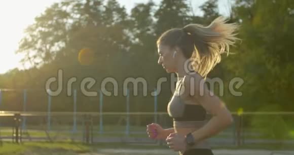 阳光明媚的一天女人在体育场奔跑的肖像视频的预览图