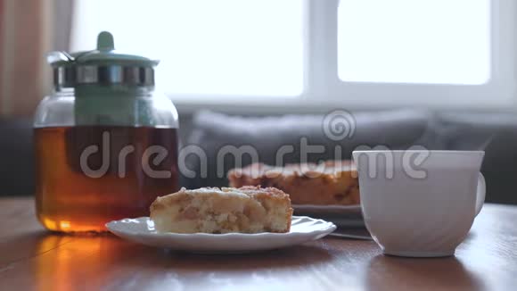 桌子上放着自制的苹果派和热茶苹果派茶壶和一杯热茶视频的预览图