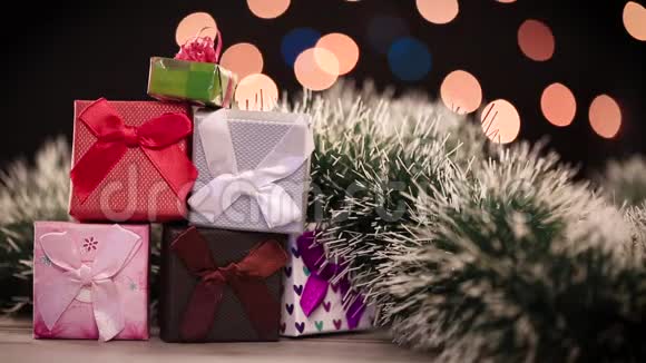 桌子上有礼品盒和圣诞树背景灯视频的预览图