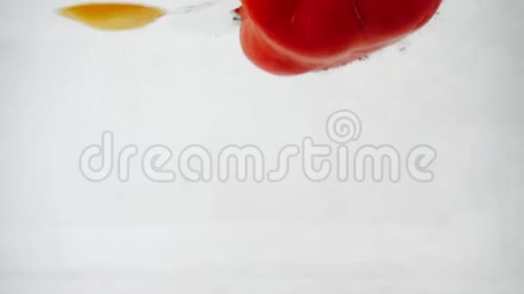 红辣椒和黄辣椒掉进水里溅起水花和气泡动作缓慢视频的预览图