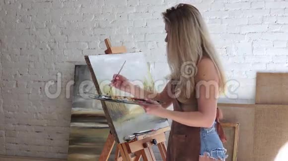女艺术家在她的工作店画画侧视视频的预览图