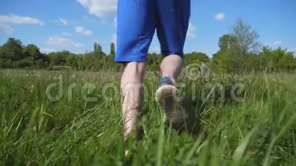 跟随着人在乡间田野奔跑年轻的运动员在草地慢跑大自然中的男运动员训练跑步者视频的预览图