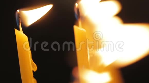 两支蜡烛在黑色背景下闪电的特写镜头视频的预览图