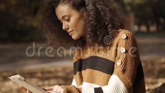 漂亮的年轻女孩深色卷发使用平板电脑户外视频的预览图
