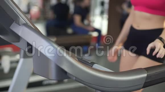 身材苗条腹部平坦的女士开始跑步机运动健身视频的预览图