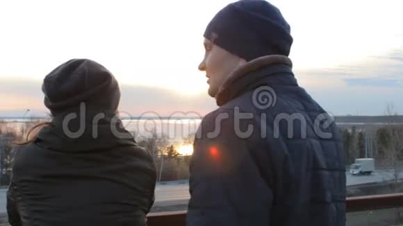 浪漫的年轻夫妇在屋顶阳台上放松享受日落视频的预览图