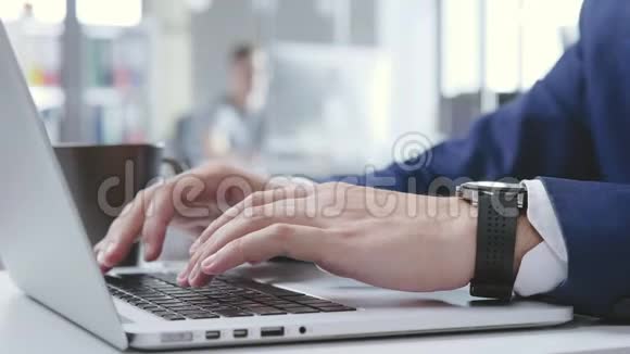 在办公室里用他的笔记本电脑紧紧抓住男性的双手视频的预览图