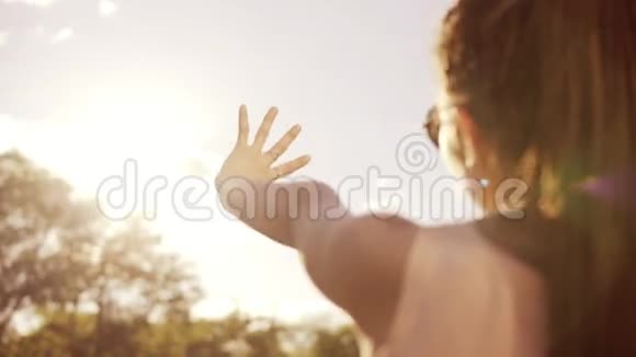 特写后景一个女人看着太阳用手躲着太阳有恐惧的年轻女子视频的预览图